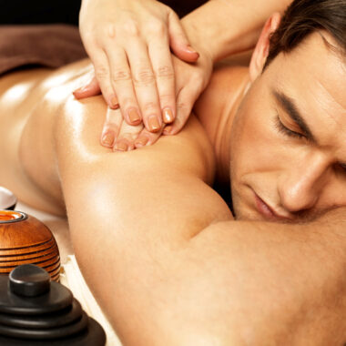 Masseur doing massage on man body in the spa salon. Beauty treatment concept.